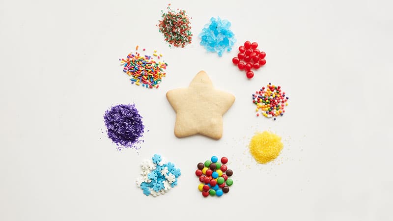Plain sugar cookie with piles of colorful decorating sprinkles