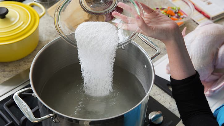 Salt being added to water to make a brine for turkey