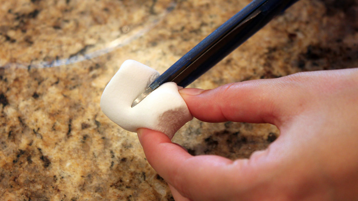 cutting large marshmallows in half with scissors