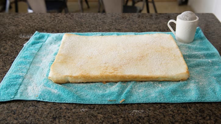angel food cake pan on towel with powdered sugar