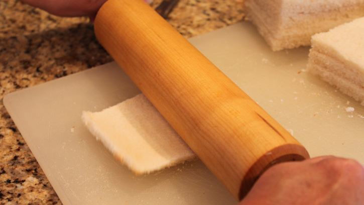flattening white bread with rolling pin
