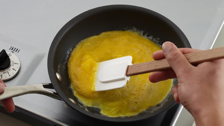 moving eggs in pan with spatula