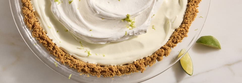 Top down shot on one third of key lime pie with sliced limes