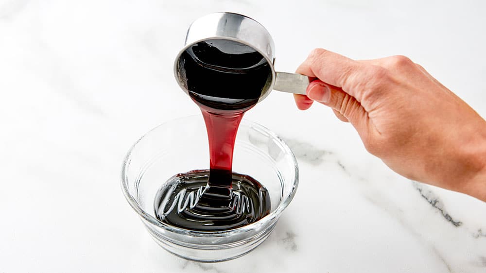 pouring syrup out of measuring cup