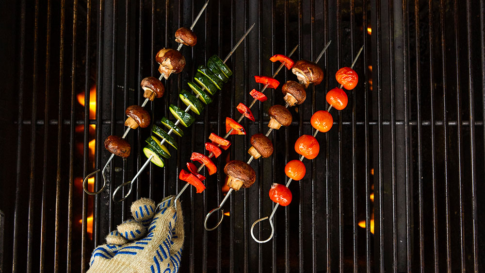 turning vegetable kabobs on the grill