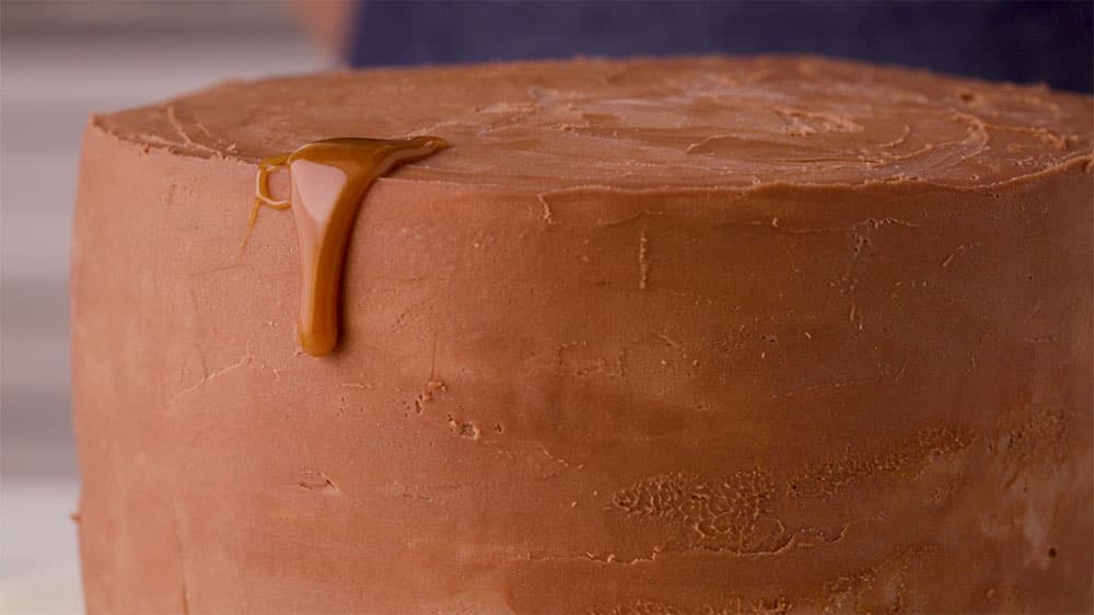 caramel dripping down frosted cake