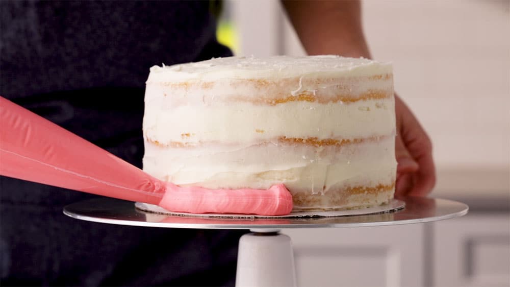 piping frosting on cake