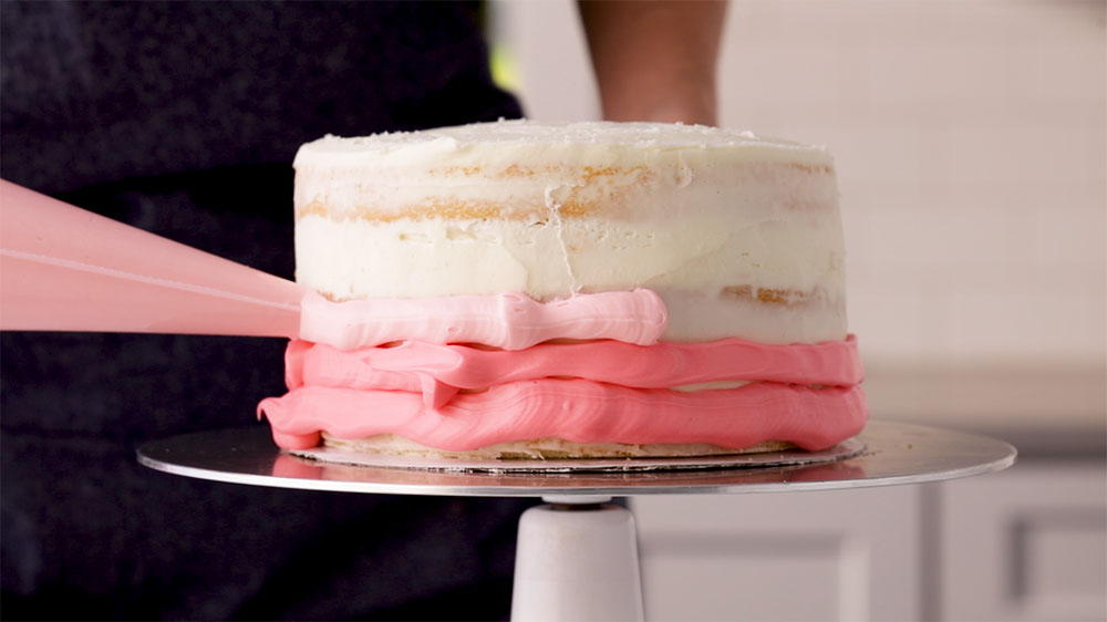 piping frosting on cake