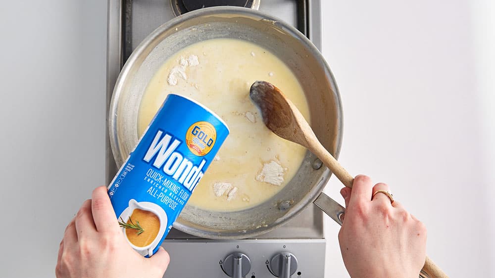 Shaking Wondra into a sauce to help it thicken. 