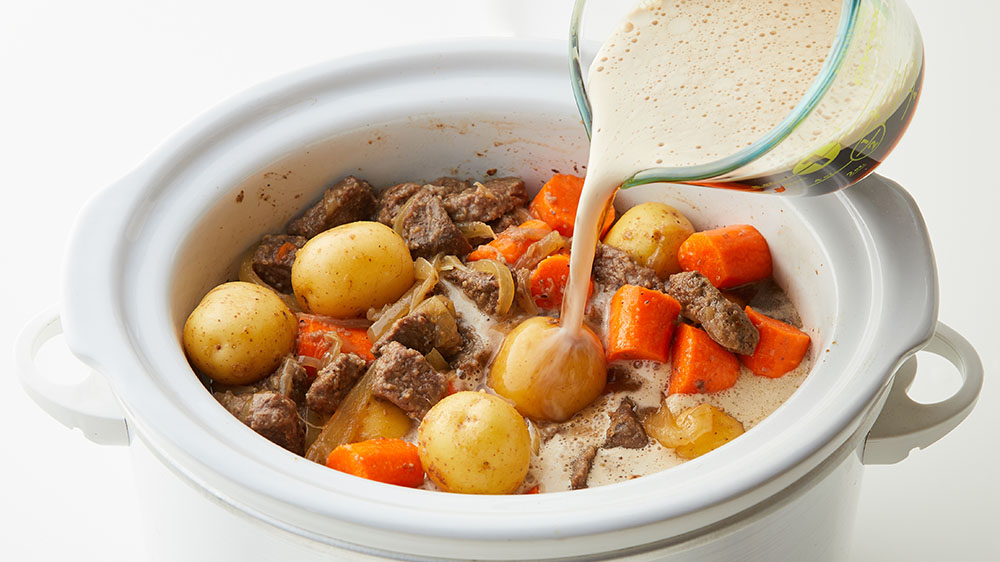 pouring sauce in slow cooker stew