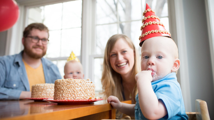 family and baby with Cheerios birthday hat and cake