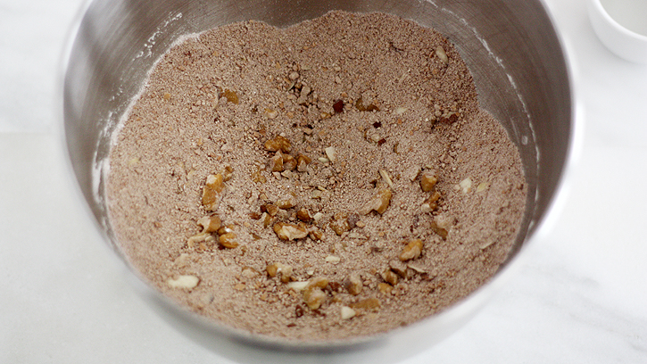 Crushed wafers in a large bowl with powdered sugar, cocoa powder and chopped nuts