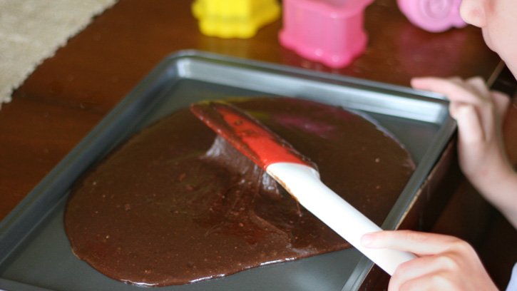 brownie batter being spread into pan