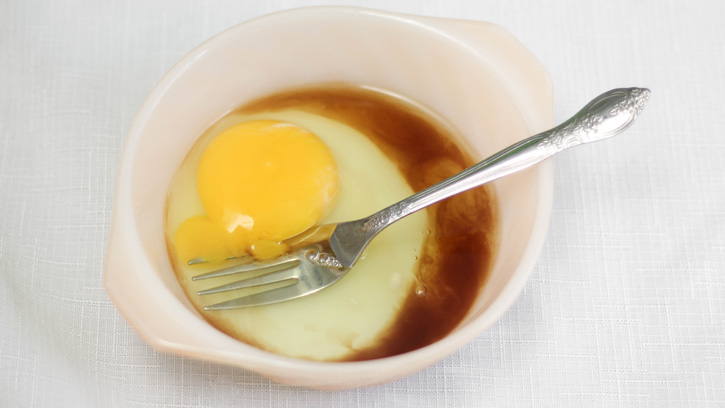 whisking egg with fork