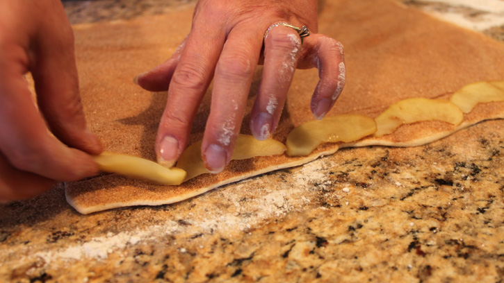 placing apples on dough strip