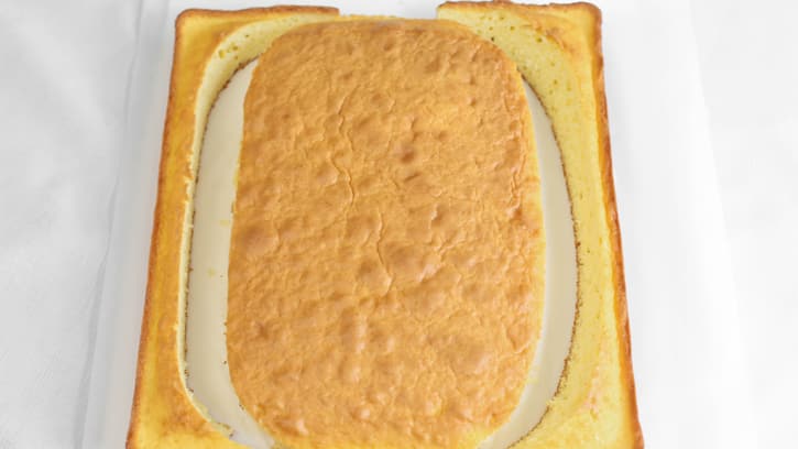 yellow sheet cake cut into an oval