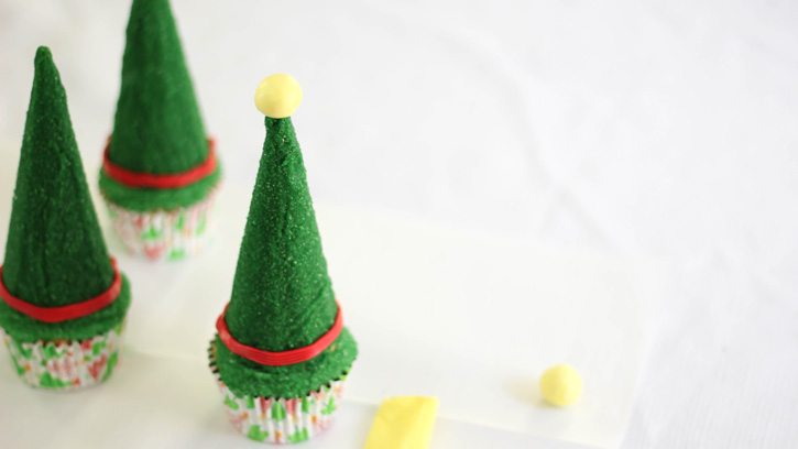 putting yellow ball of taffy on top of green cone