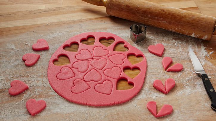 cutting out hearts with pink dough