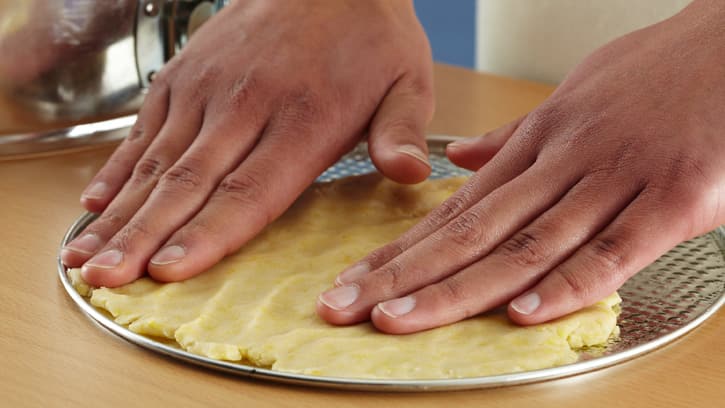 flattening dough in bottom of pan