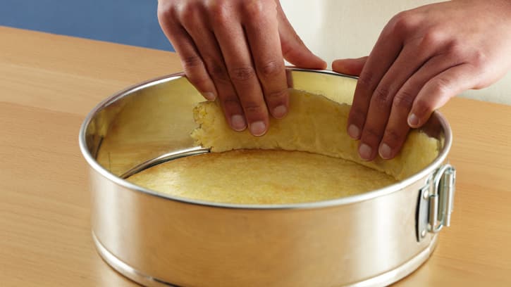 pressing dough up sides of springform pan