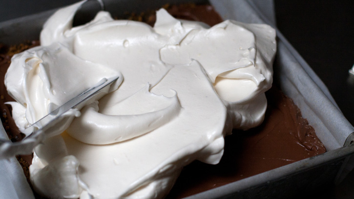 spreading meringue on top of ice cream bars