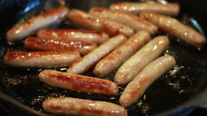 frying sausages in a pan