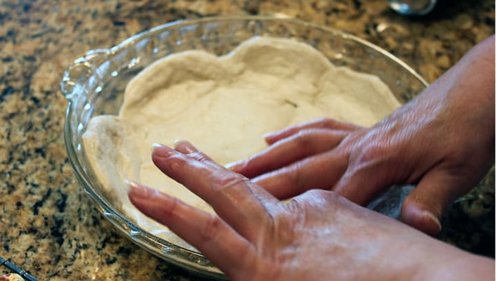 pressing biscuit dough into pie plate