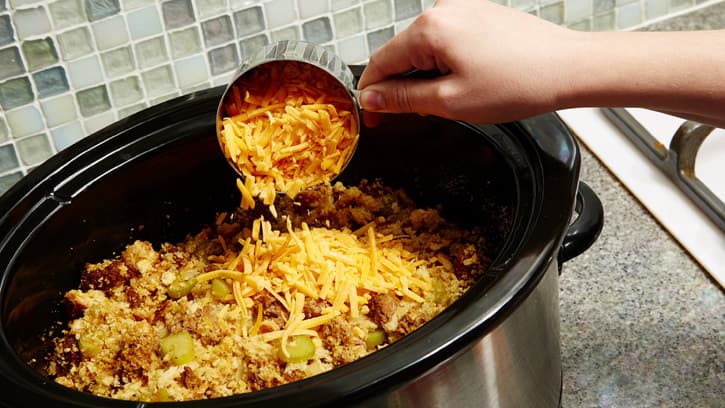 adding shredded cheese to slow cooker