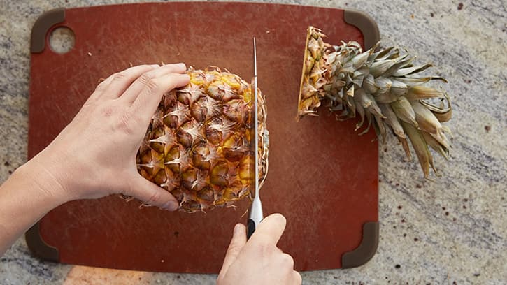 Remove the crown and base of the pineapple